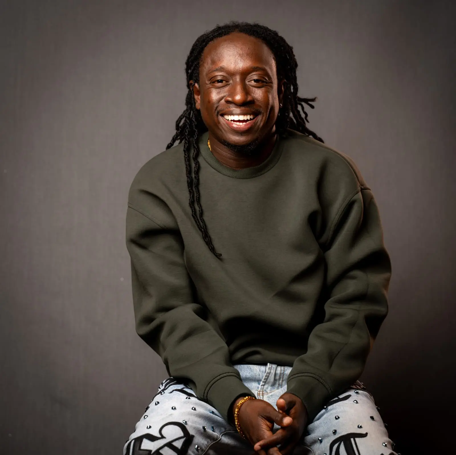 Samuel Medas smiling in a dark green sweatshirt